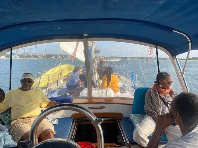 Guests relaxing in the cockpit and forward deck of the sailboat