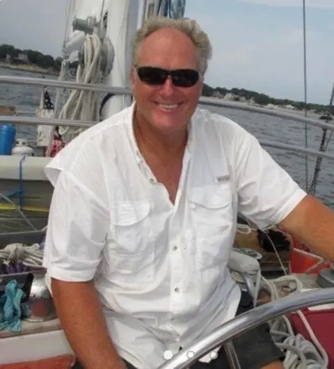 Smiling captain in sunglasses seated on the boat