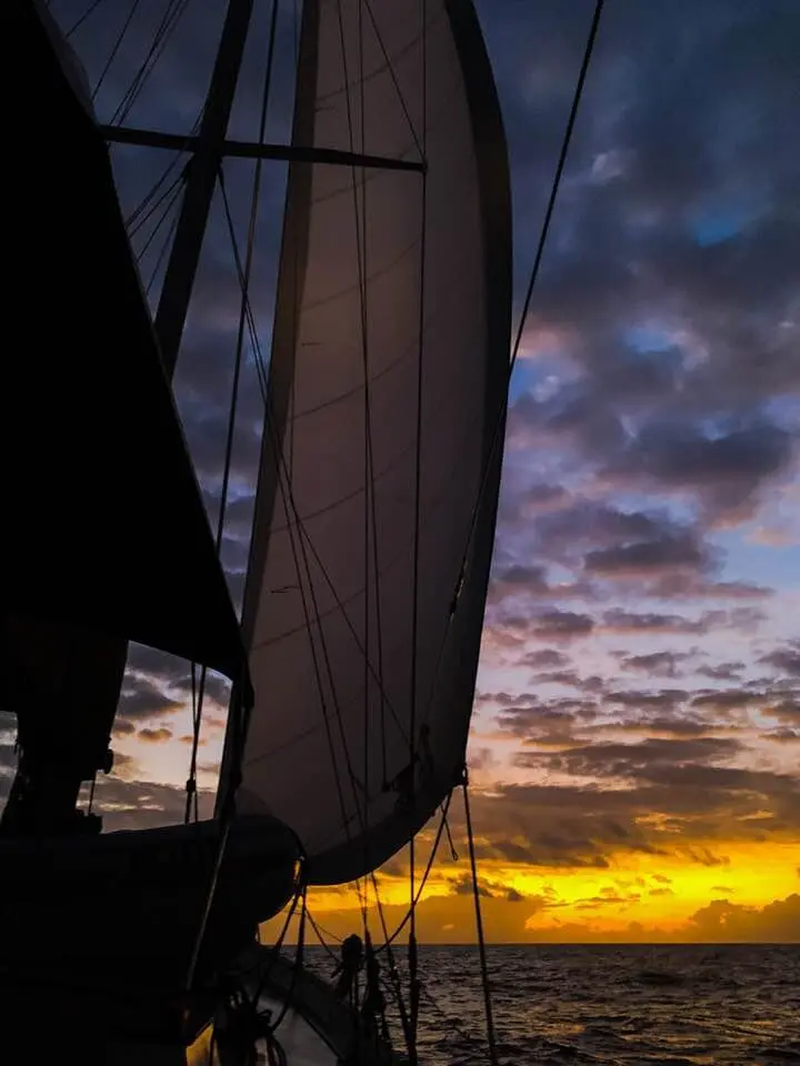 Sailboat on the water at sunset with colorful sky, New England